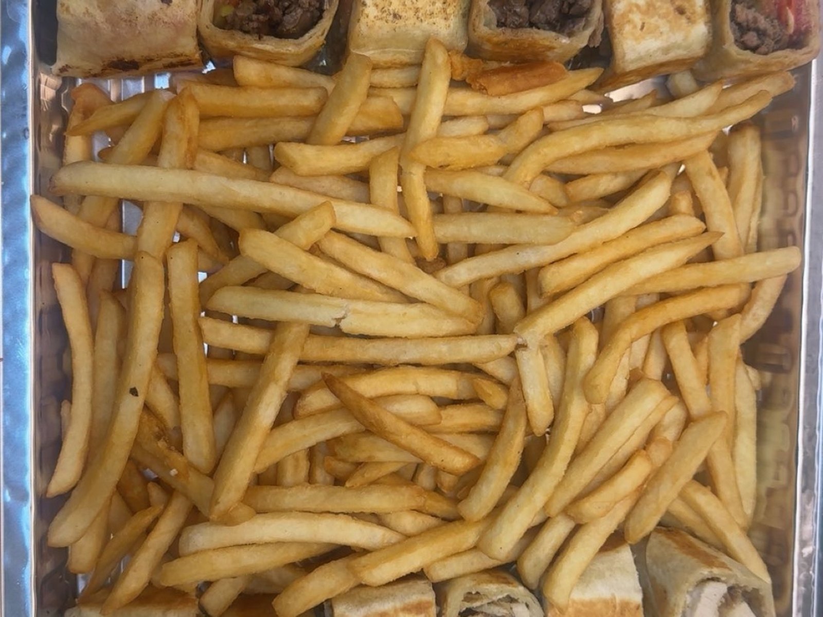 Party tray of beef and chicken shawarma rolls with fries