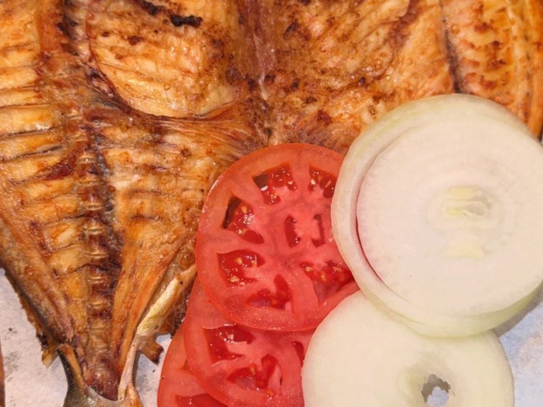 Grilled fish with lemon, tomato and onion